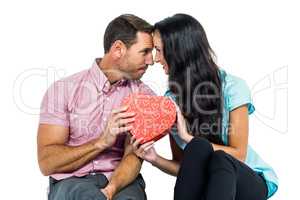 Happy couple holding heart shaped box