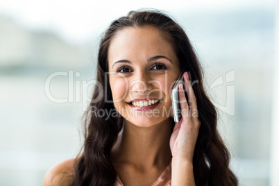 Smiling woman on phone call looking at camera