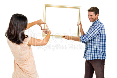 Happy young couple hanging picture frame