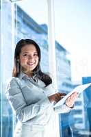 Smiling businesswoman using tablet and looking at camera