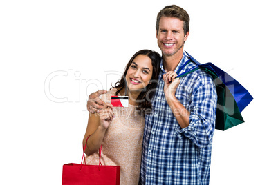 Portrait of cheerful couple with shopping bags and credit card