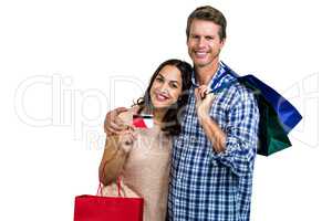 Portrait of cheerful couple with shopping bags and credit card