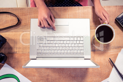 Cropped image of hands using laptop at creative office