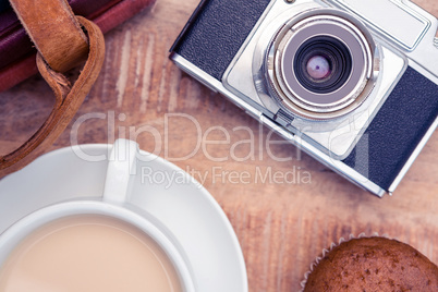 Close-up of old camera with diaries and coffee