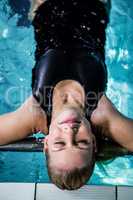 Relaxed woman floating in the swimming pool