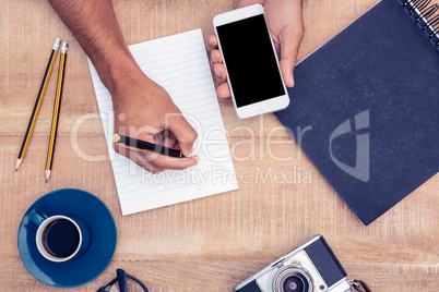 High angle view of businessman writing on notepad