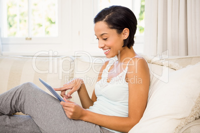 Smiling brunette using tablet