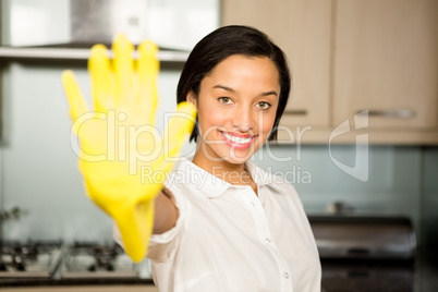Smiling brunette showing yellow glove