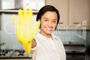 Smiling brunette showing yellow glove