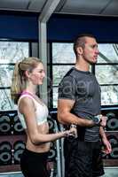 Smiling fit couple lifting dumbbells