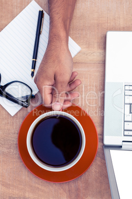 Businessman having coffee on desk in office