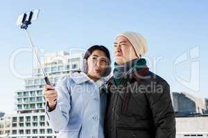 Couple clicking funny pictures through mobile phone