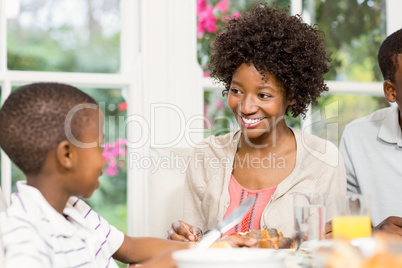 Smiling son eating his dinner