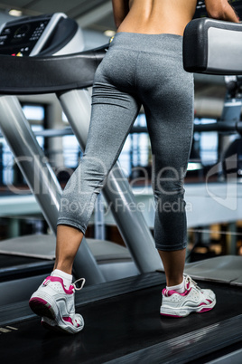 Mid section of woman using treadmill