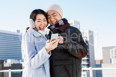 Cheerful couple looking at the smart phone