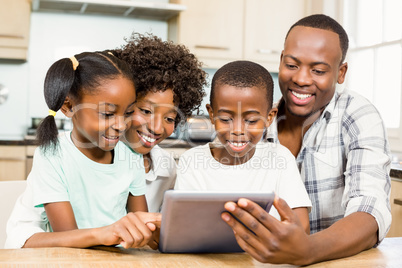 Happy family using tablet in kitchen