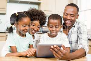 Happy family using tablet in kitchen