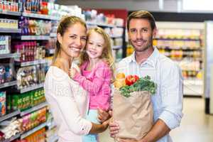 Smiling family with grocery bag at the supermarket