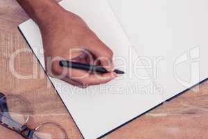 Overhead view of  businessman writing on notebook