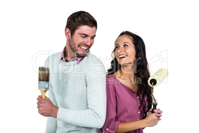 Smiling couple holding brushes