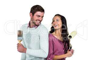 Smiling couple holding brushes