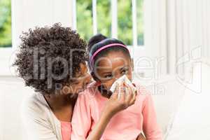 Mother helping daughter blowing her nose