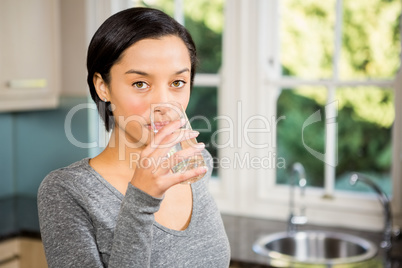 Smiling brunette drinking water