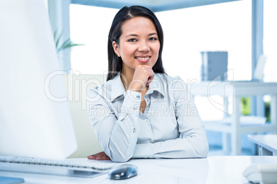 Smiling businesswoman with chin on fist