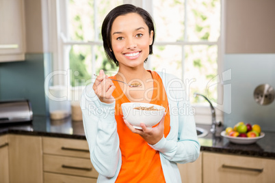 Happy brunette eating cereals