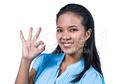 Smiling businesswoman doing ok sign