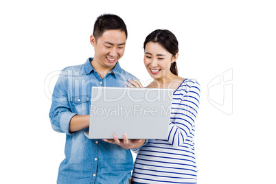 Cheerful couple using laptop