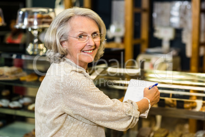 Smiling senior woman checking list