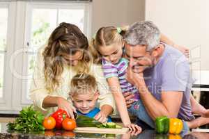 Happy family slicing vegetables