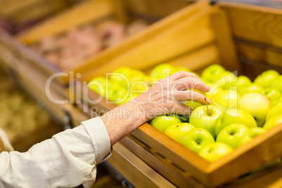 Senior woman picking out a green apple