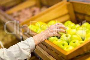 Senior woman picking out a green apple