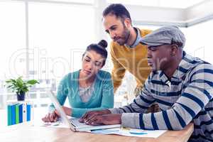 Business man using laptop with colleagues in background