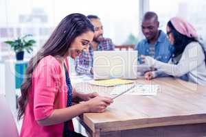 Happy young businesswoman using digital tablet