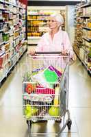 Concentrated senior woman pushing trolley