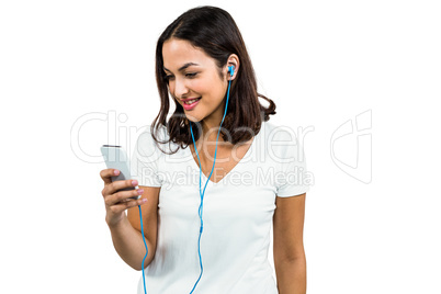 Happy woman listening music while using mobile phone