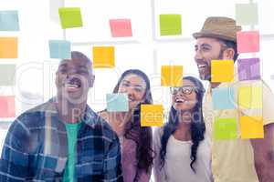 Smiling business people standing in front of adhesive notes