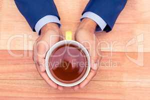 Cropped hands of businessman holding coffee cup