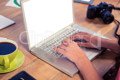 Cropped image of hands using laptop