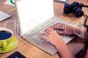 Cropped image of hands using laptop