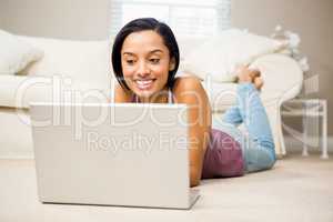 Smiling brunette using laptop