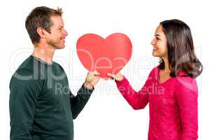 Smiling couple holding red heart shape