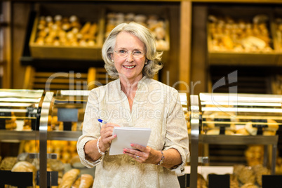 Smiling senior woman checking list