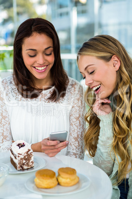 two girls watch a phone