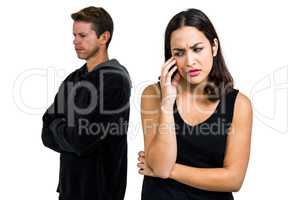 Depressed couple standing against white background