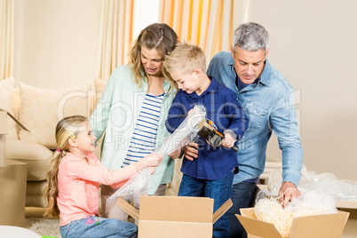 Portrait of happy family opening boxes