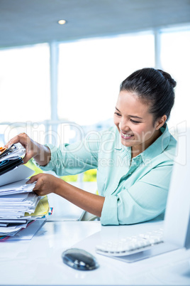 Smiling businesswoman searching files